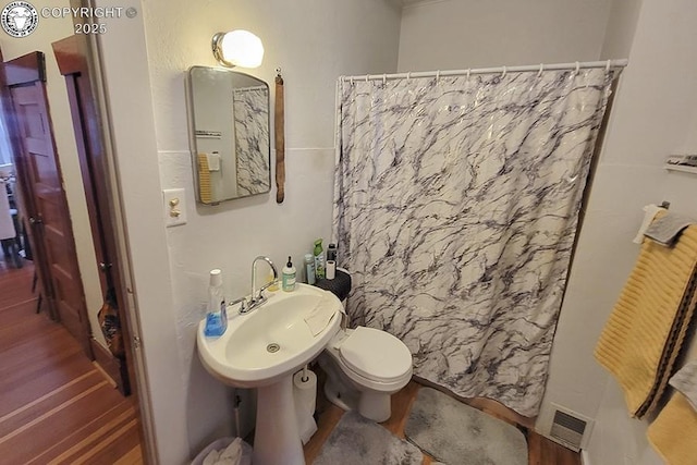 bathroom with a shower with curtain, toilet, and sink