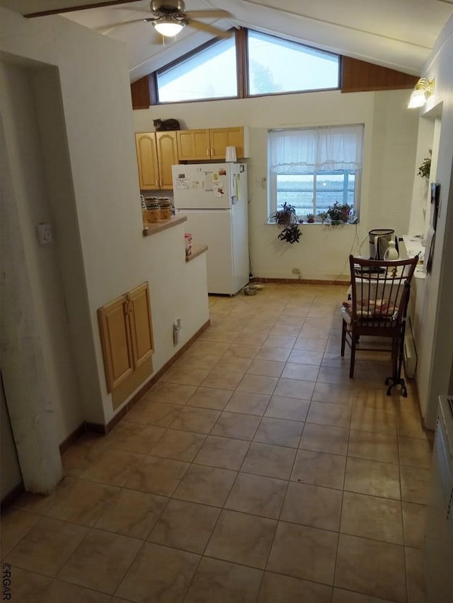 kitchen featuring light brown cabinetry, lofted ceiling with beams, white fridge, light tile patterned floors, and ceiling fan