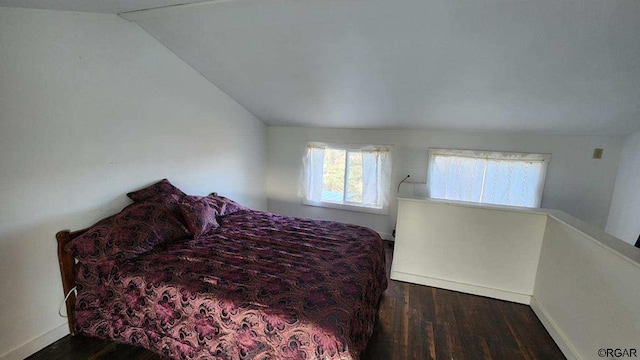 bedroom with dark wood-type flooring and vaulted ceiling