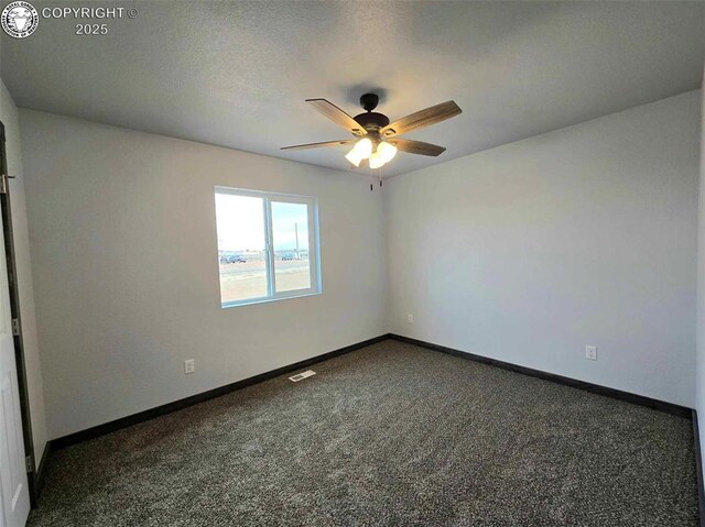 spare room with dark carpet and ceiling fan