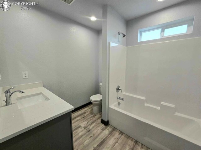 full bathroom featuring vanity, wood-type flooring,  shower combination, and toilet