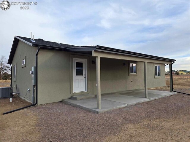 back of property featuring central AC unit and a patio