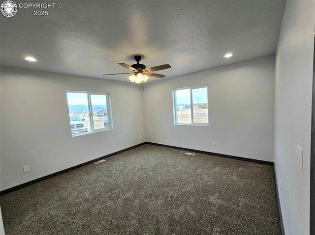 unfurnished room featuring dark colored carpet, plenty of natural light, and a textured ceiling