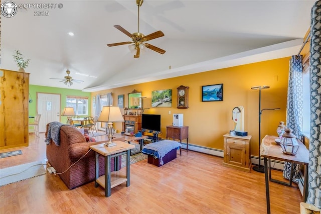 living area with lofted ceiling, ceiling fan, baseboard heating, and wood finished floors