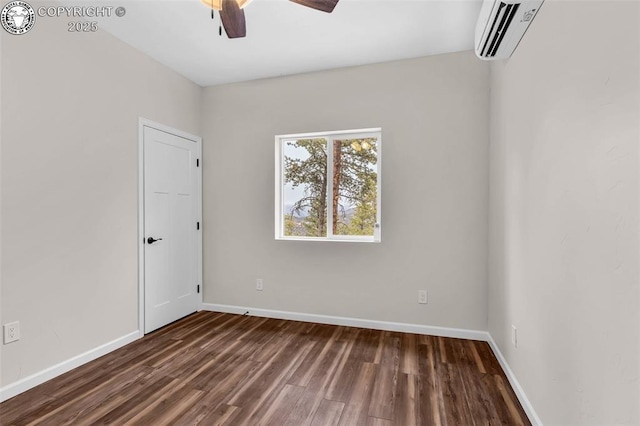 spare room featuring an AC wall unit, baseboards, dark wood-type flooring, and ceiling fan