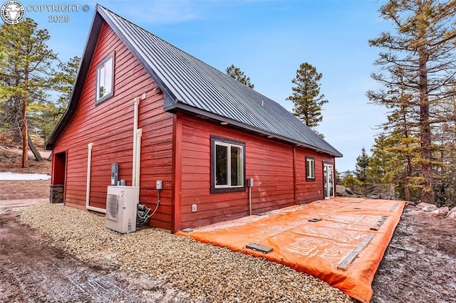 view of home's exterior featuring a patio, ac unit, and metal roof