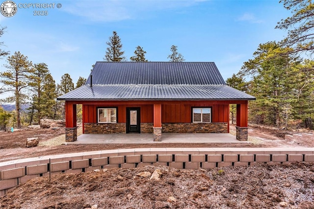 chalet / cabin featuring stone siding, board and batten siding, and covered porch