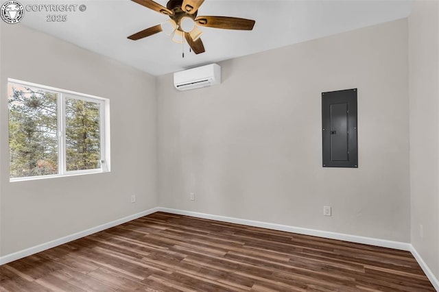 empty room featuring a ceiling fan, a wall mounted AC, electric panel, dark wood finished floors, and baseboards