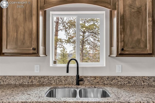 room details featuring light stone countertops and a sink