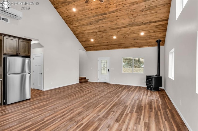 unfurnished living room featuring wood ceiling, high vaulted ceiling, a wood stove, and wood finished floors