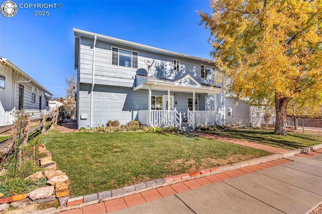 view of front of property featuring a balcony, fence, a front lawn, and a porch