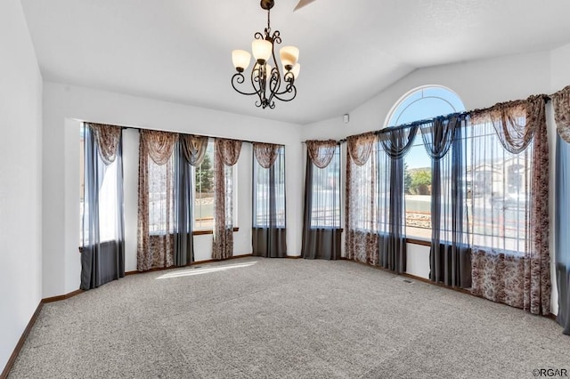 carpeted spare room featuring vaulted ceiling and a notable chandelier