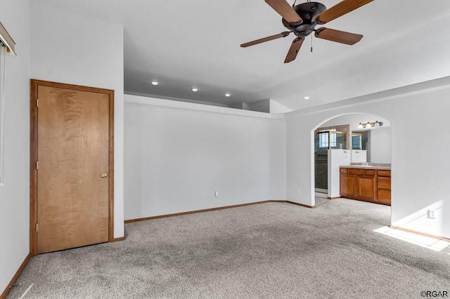 unfurnished living room featuring vaulted ceiling, light colored carpet, and ceiling fan