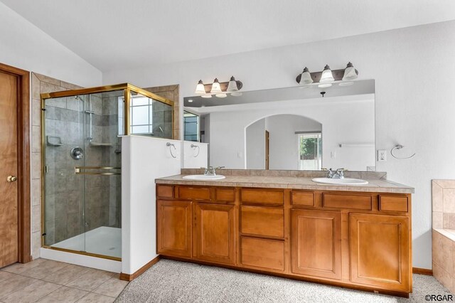 bathroom featuring plus walk in shower, vaulted ceiling, vanity, and tile patterned floors