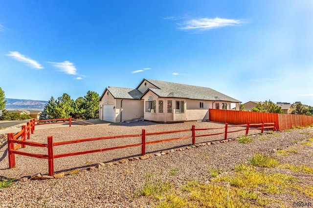 back of property with a garage and a mountain view