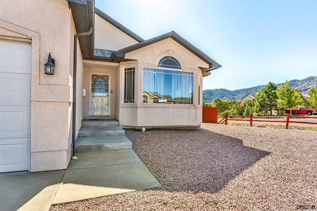 view of exterior entry featuring a garage and a mountain view