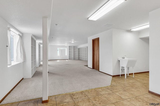 basement featuring light colored carpet and a healthy amount of sunlight