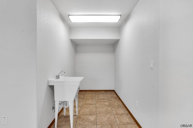 clothes washing area with light tile patterned floors