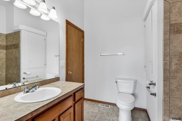 bathroom with an inviting chandelier, vanity, toilet, and tile patterned flooring