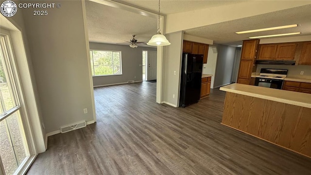 1157 County Road 119, Florence, CO 81226 - kitchen with black refrigerator with ice dispenser, electric range, brown cabinets, under cabinet range hood, and dark wood-style floors