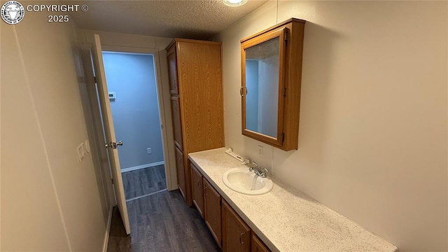 1157 County Road 119, Florence, CO 81226 - bathroom featuring vanity, wood finished floors, a textured ceiling, and baseboards