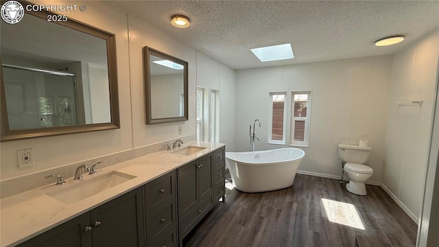 1157 County Road 119, Florence, CO 81226 - bathroom with a skylight, wood finished floors, a freestanding bath, a textured ceiling, and a shower stall