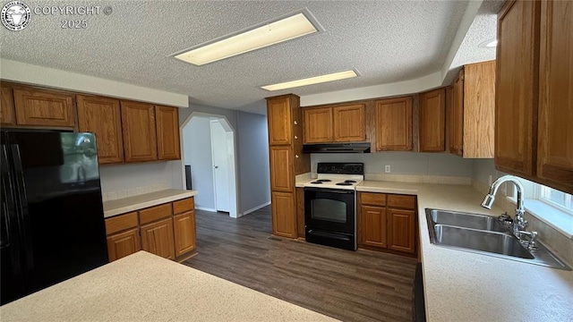 1157 County Road 119, Florence, CO 81226 - kitchen featuring freestanding refrigerator, range with electric cooktop, range hood, a sink, and brown cabinetry