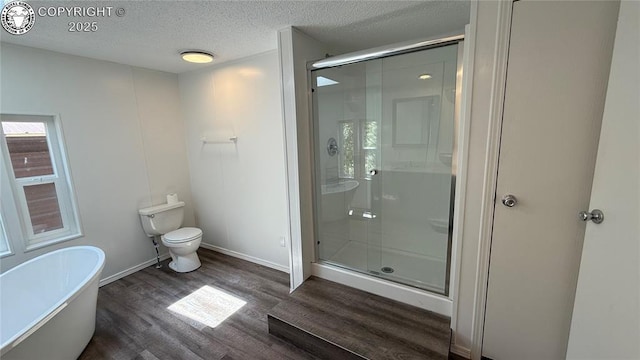 1157 County Road 119, Florence, CO 81226 - full bath featuring wood finished floors, a freestanding tub, a stall shower, toilet, and a textured ceiling