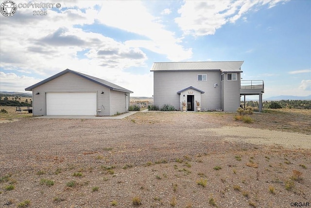 136 Arapahoe Cir, Westcliffe, CO 81252 - back of house with a garage, a balcony, an outdoor structure, and metal roof