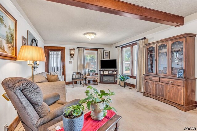 carpeted living room with beam ceiling and a textured ceiling