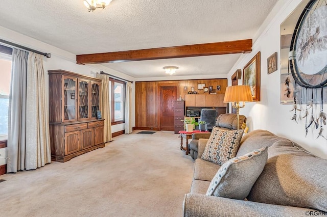 carpeted living room featuring beamed ceiling, wooden walls, and a textured ceiling