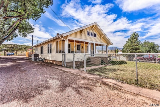 view of front of house featuring central AC unit, covered porch, and a front lawn