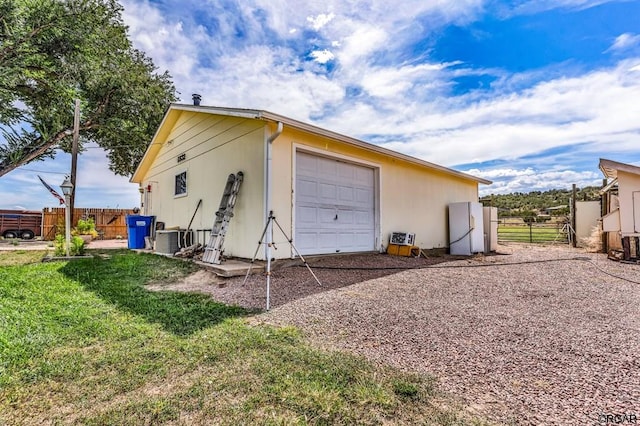 garage with a lawn, central air condition unit, and white refrigerator