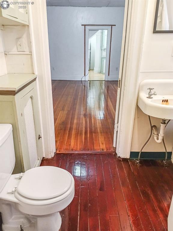 bathroom with toilet and hardwood / wood-style floors