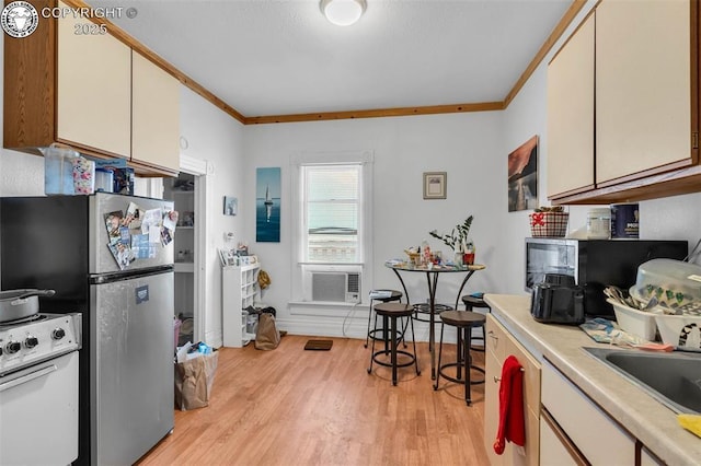 kitchen with light wood-type flooring, ornamental molding, stainless steel refrigerator, and white stove