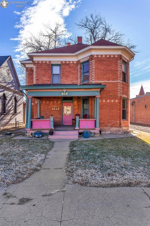 view of front of home with a porch and a front lawn