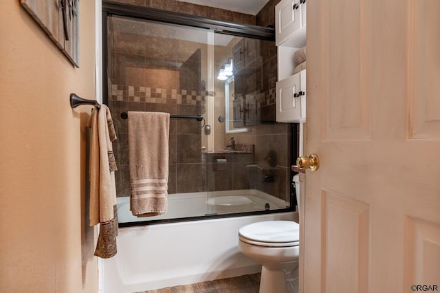 bathroom featuring shower / bath combination with glass door and toilet