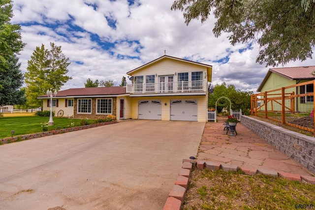 view of front of property featuring a balcony, a garage, and a front yard