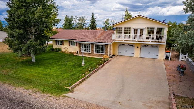 view of front facade with a garage, a front yard, and a balcony