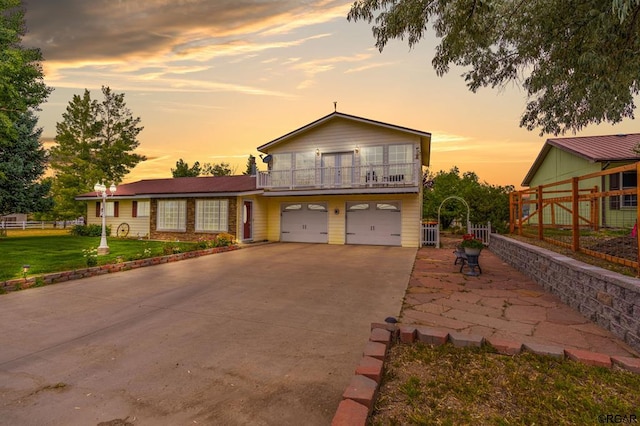 view of front of home with a balcony, a garage, and a lawn