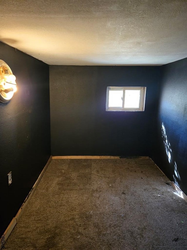 spare room featuring a textured ceiling and carpet flooring