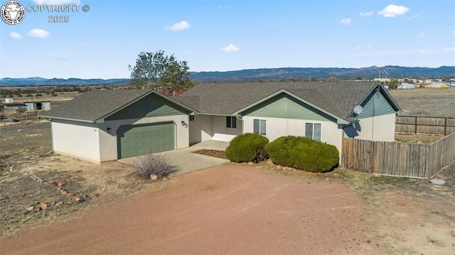 ranch-style home with a garage and a mountain view