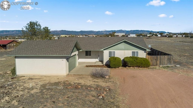 ranch-style house with a garage and a mountain view