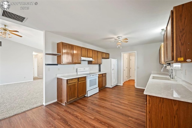 kitchen with sink, white appliances, wood-type flooring, and ceiling fan