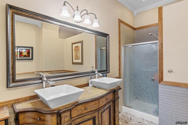 bathroom featuring ornamental molding, tile patterned flooring, a shower with door, and vanity