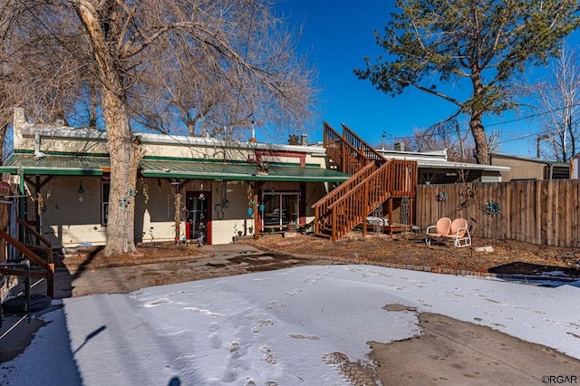 view of snow covered back of property