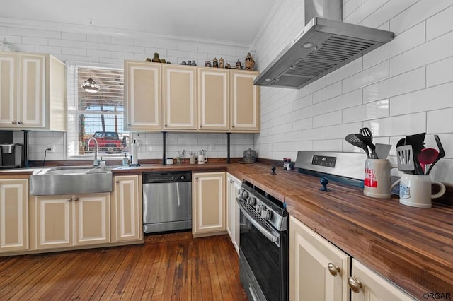 kitchen featuring stainless steel appliances, cream cabinets, ventilation hood, and wooden counters