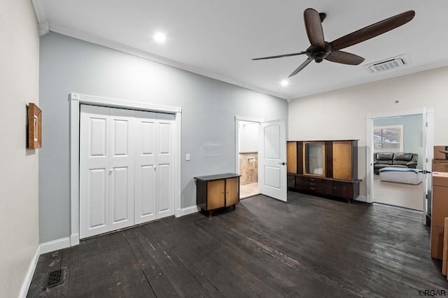 unfurnished bedroom featuring dark wood-type flooring, ceiling fan, ornamental molding, and a closet