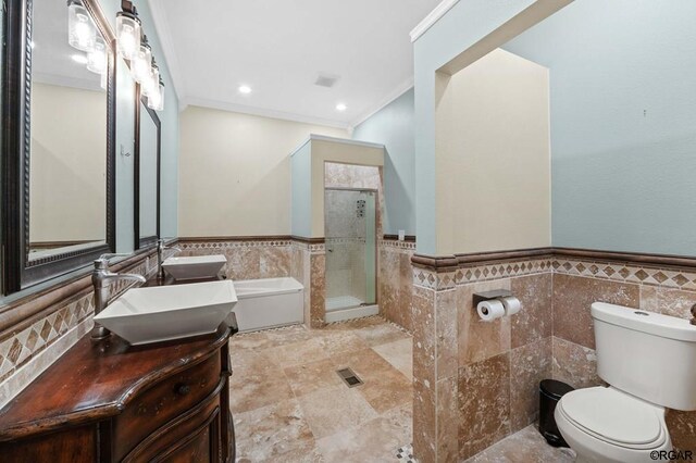 full bathroom featuring toilet, crown molding, tile walls, vanity, and independent shower and bath