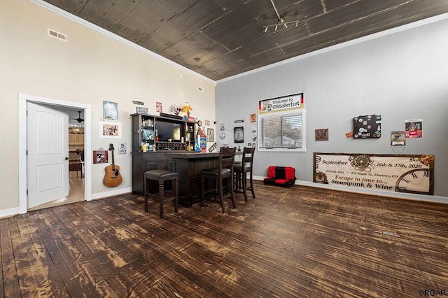 bar with dark hardwood / wood-style flooring and crown molding